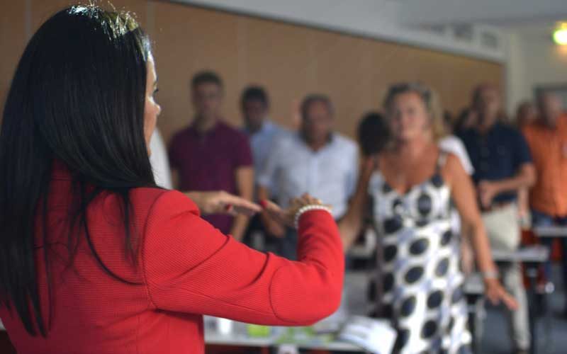 Frau in rotem Hemd während Seminar vor Publikum, Mentaltraining