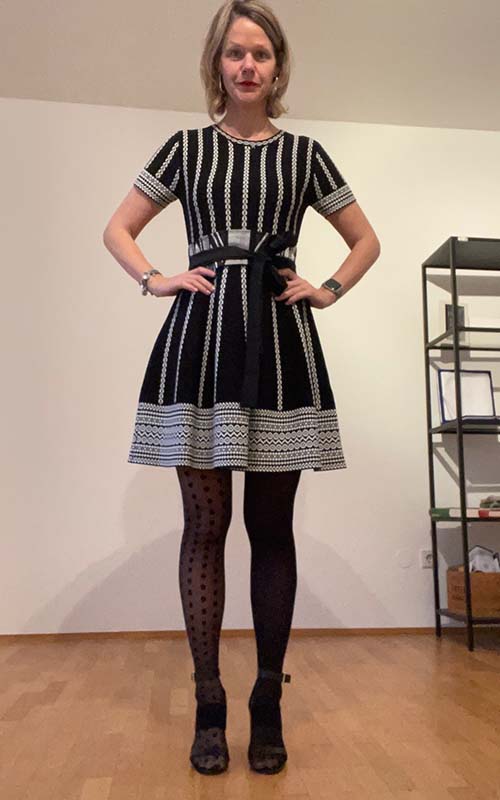 Frau in dunklem gestreiftem Kleid mit Pünktchen-Strumpfhose, Vorher-Foto