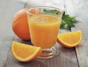 Frischer Orangensaft in Glas mit Orangenscheiben, Superfood Getränk