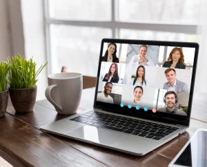 Videokonferenz auf Laptop-Bildschirm mit acht Teilnehmern in verschiedenen Fenstern