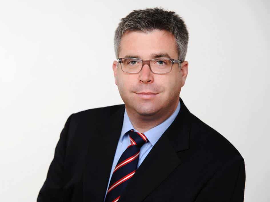Mann mit Brille im Business-Anzug, Kundenstimme Sebastian Lang
