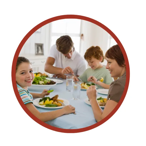 Familie beim gemeinsamen Essen am Tisch mit Gemüse und Obst