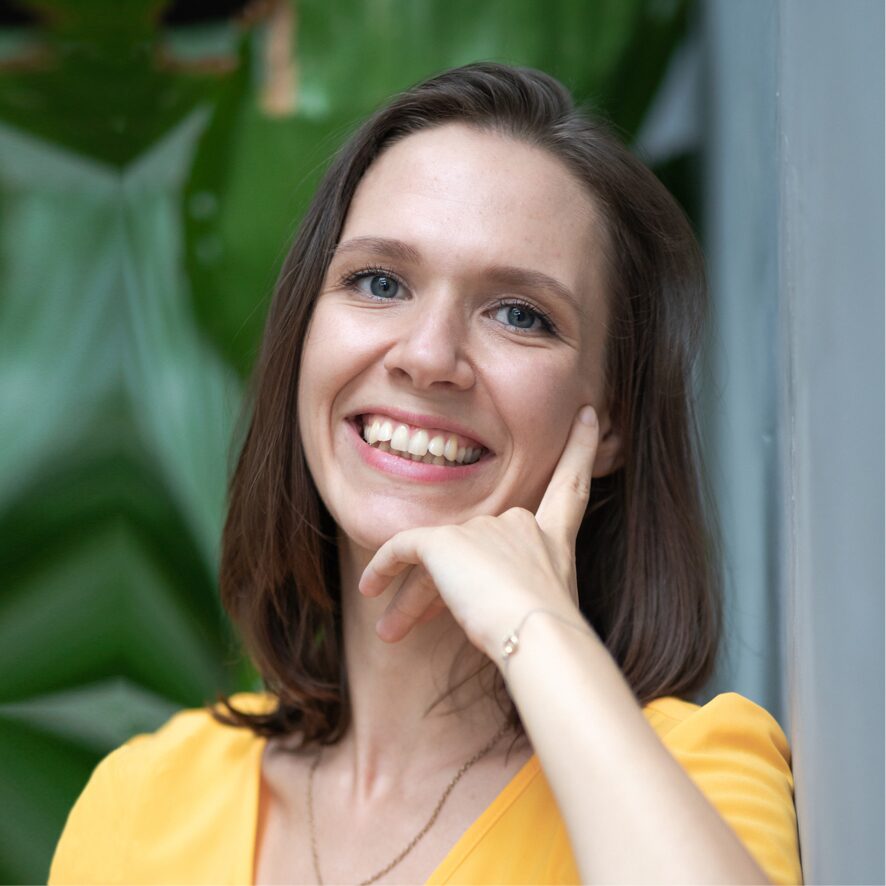 Portraitfoto von Elena Patzer, Frau mit dunklen Haaren in gelbem Oberteil
