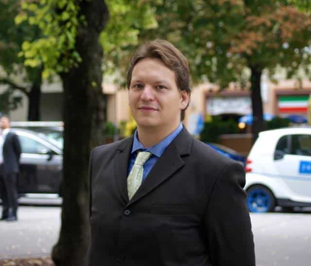 Fotografie von René Fürst im Business-Outfit vor urbaner Kulisse