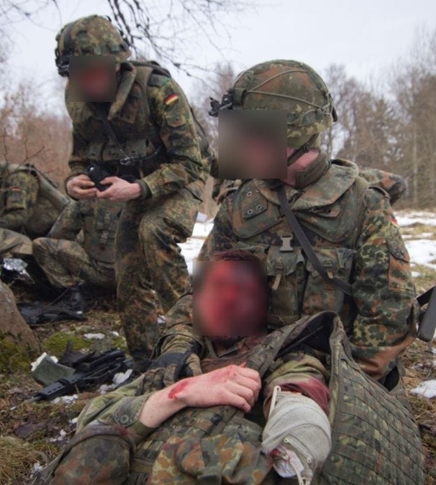 Zwei Soldaten in Flecktarn-Uniform führen taktische Medizin durch