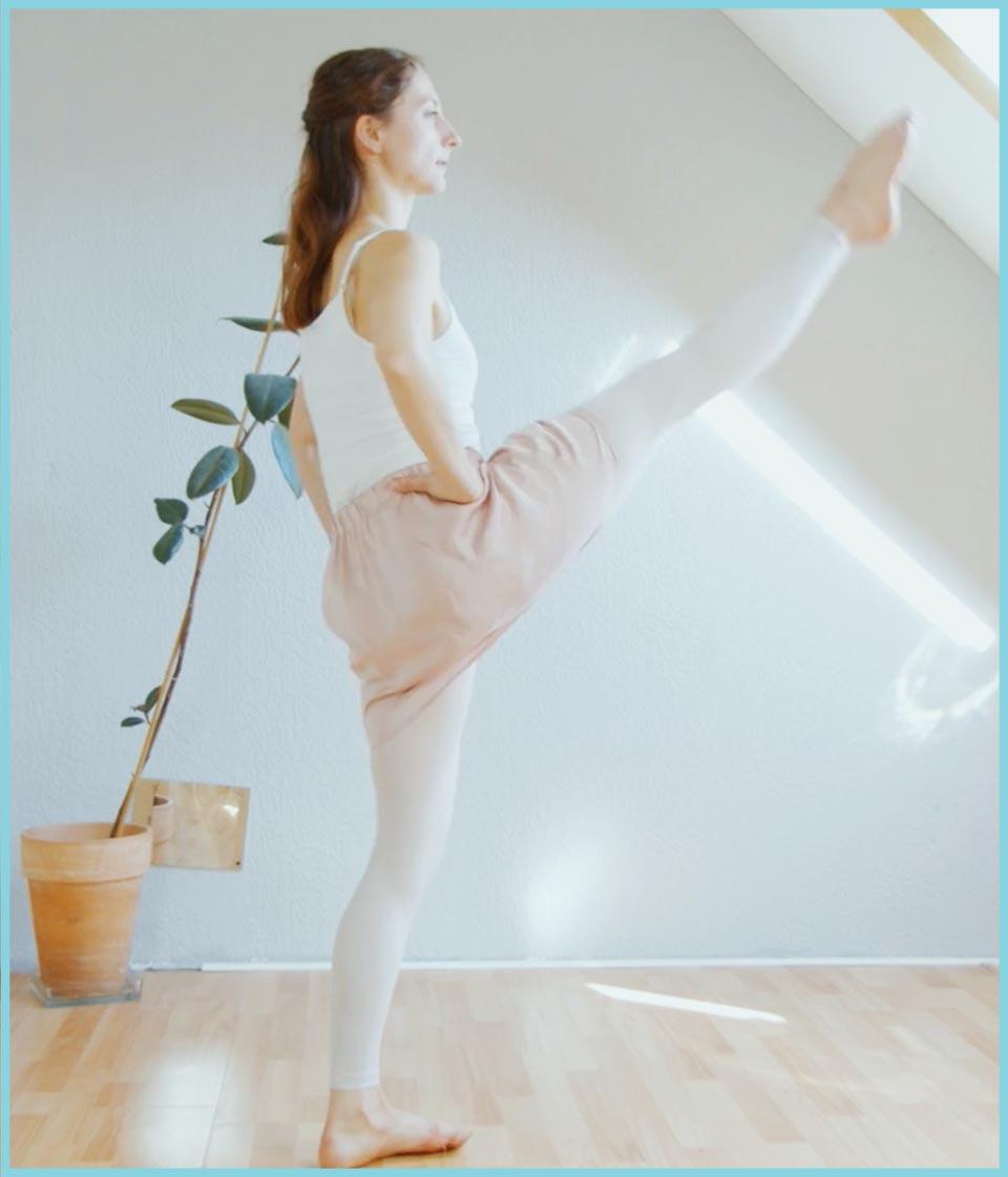 Balletttänzerin in weißem Top und rosa Rock in classicher Ballettposition neben Pflanze