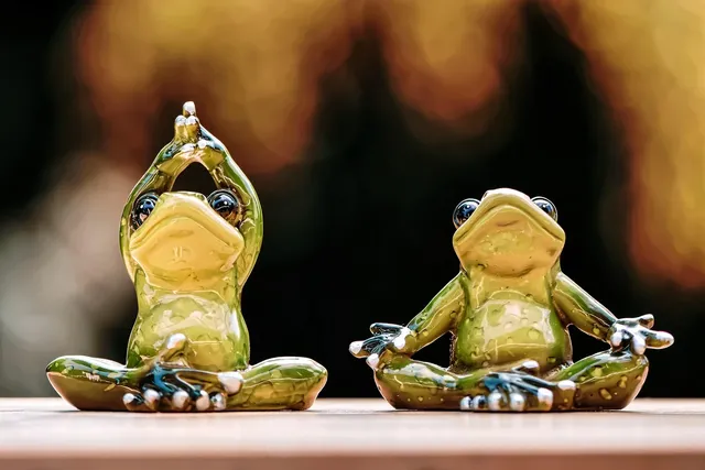 Zwei grüne Frosch-Figuren aus Glas oder Keramik in meditierender Position