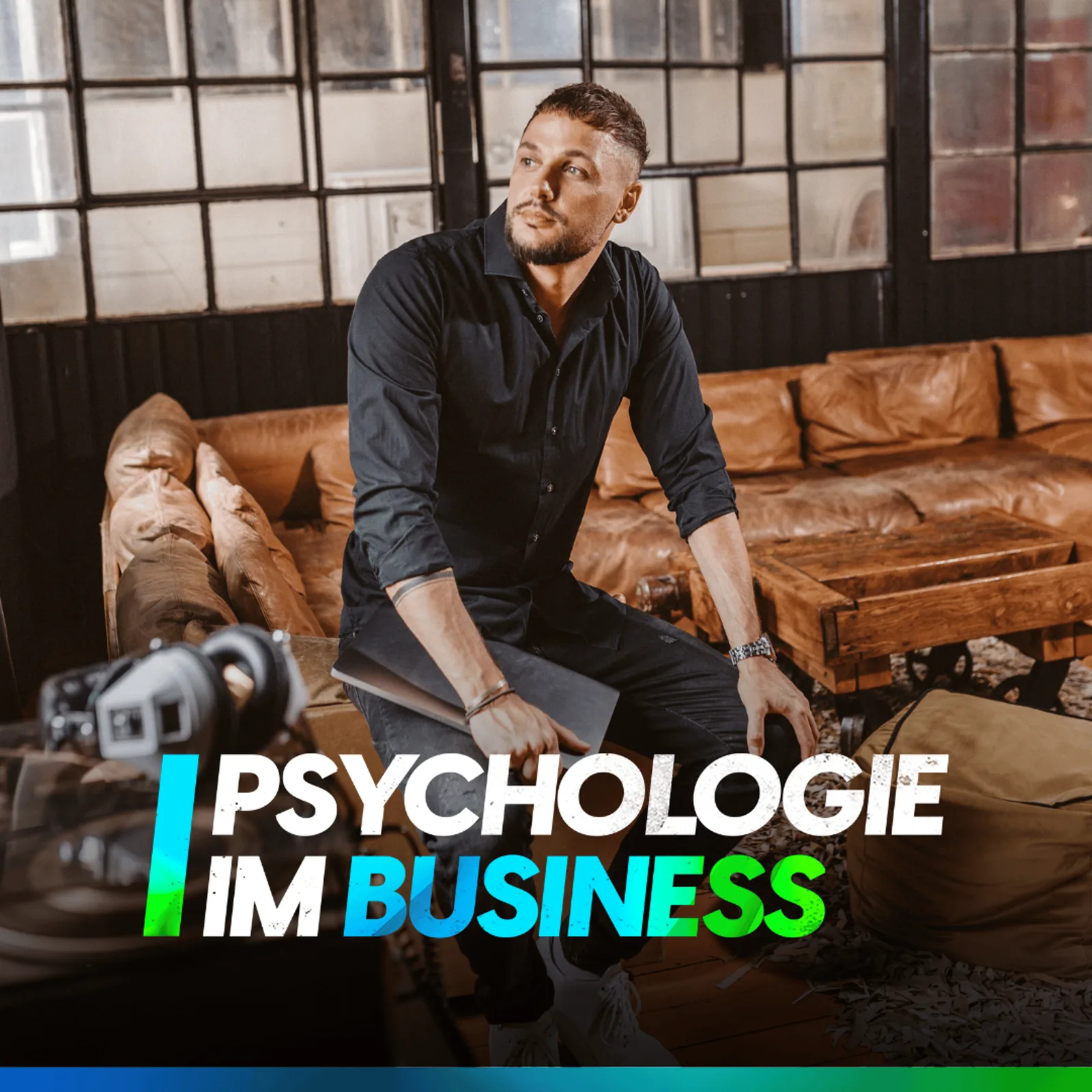 Sebastian Fröder sitzt auf braunem Ledersofa in Studio, Text Psychologie im Business