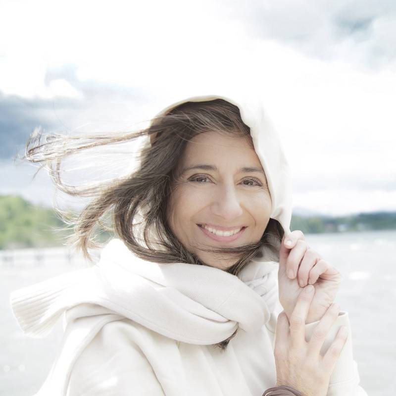 Stella van Hasselt Portrait am See mit weißem Schal, lächelnd