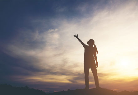 The Healed Soul – E-Book über Manifestation 4 Silhouette einer Frau mit erhobener Hand gegen Sonnenuntergang am Berg