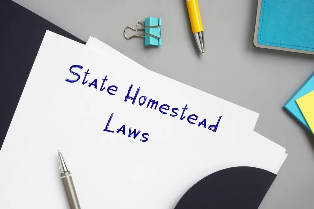 Notizblatt mit handschriftlichem Text State Homestead Laws auf Schreibtisch
