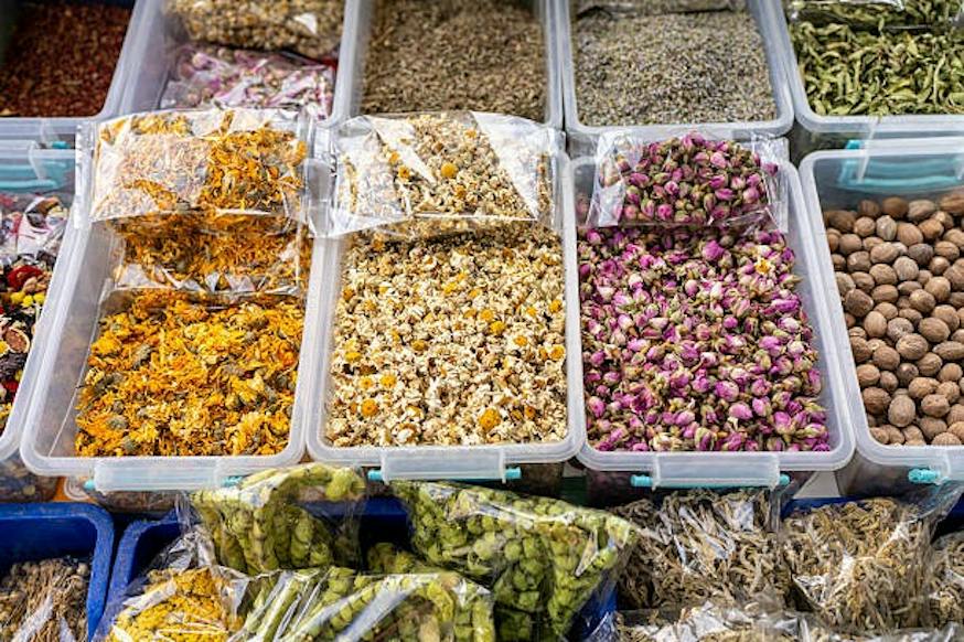 Kunststoffbehälter mit getrockneten Kräutern und Blüten auf Markt