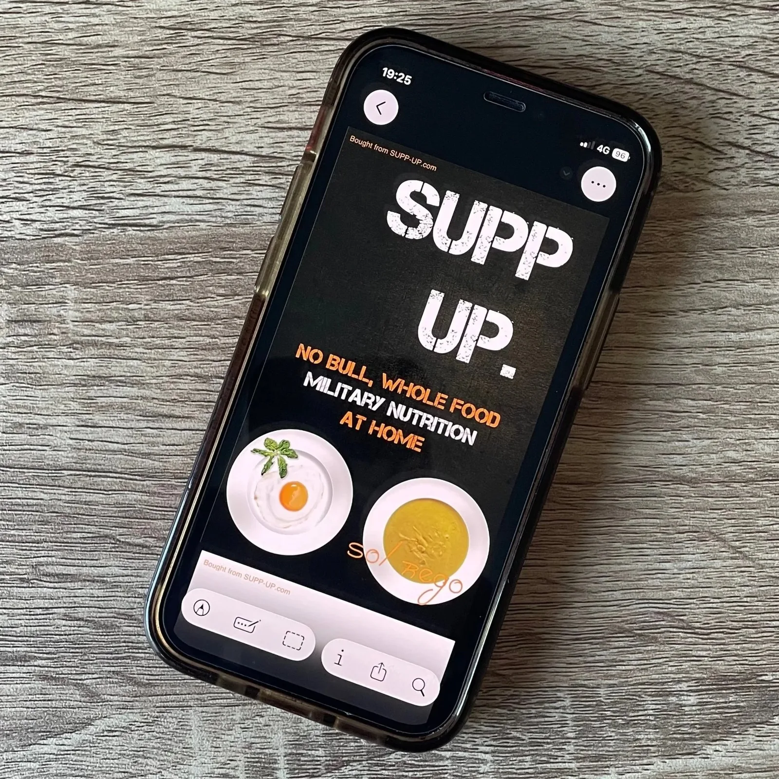 The SUPP UP. No Bull Nutrition At Home Field Guide 2 SUPP UP Nutrition At Home Field Guide Cover auf Smartphone-Display, schwarzer Hintergrund mit weißem Logo und Lebensmittelfot