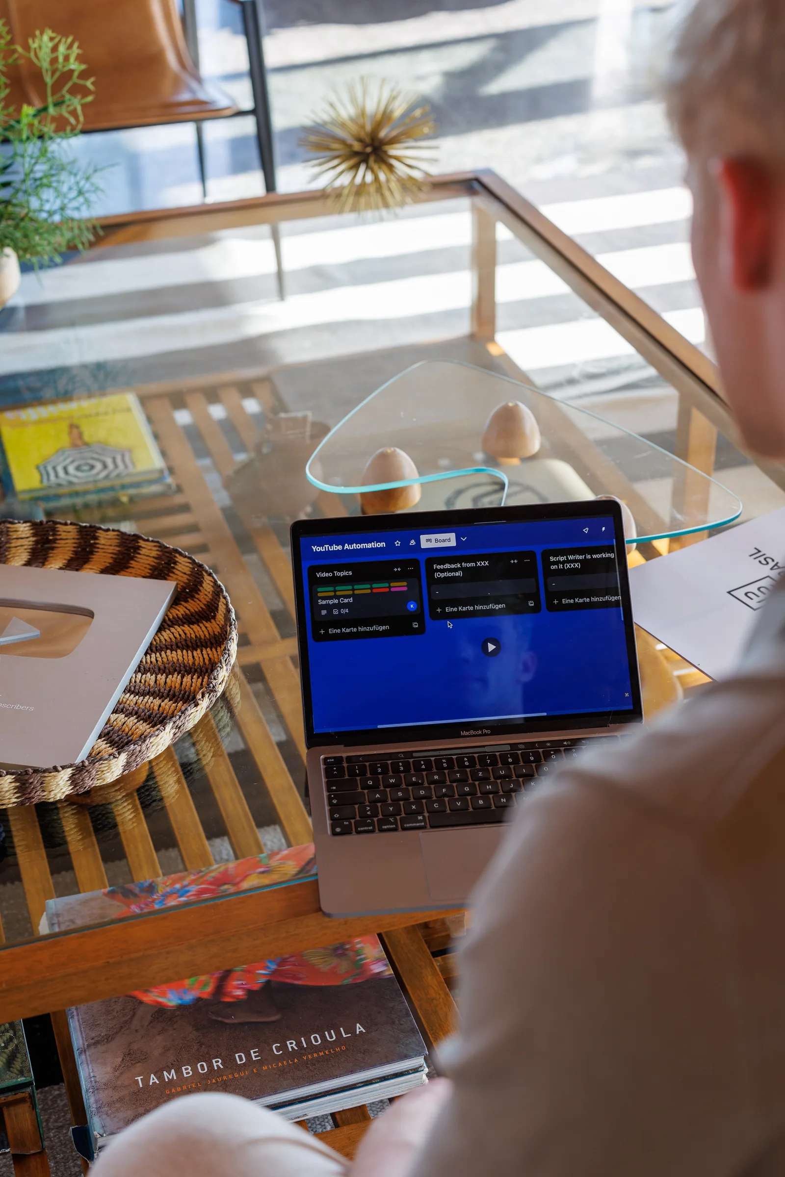 Schreibtisch mit Laptop zeigt YouTube-Automation-Software mit Notizen und Dekoration