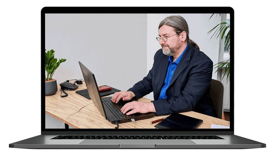 Laptop-Mockup mit Mann in Anzug und blauem Hemd an Schreibtisch arbeitend
