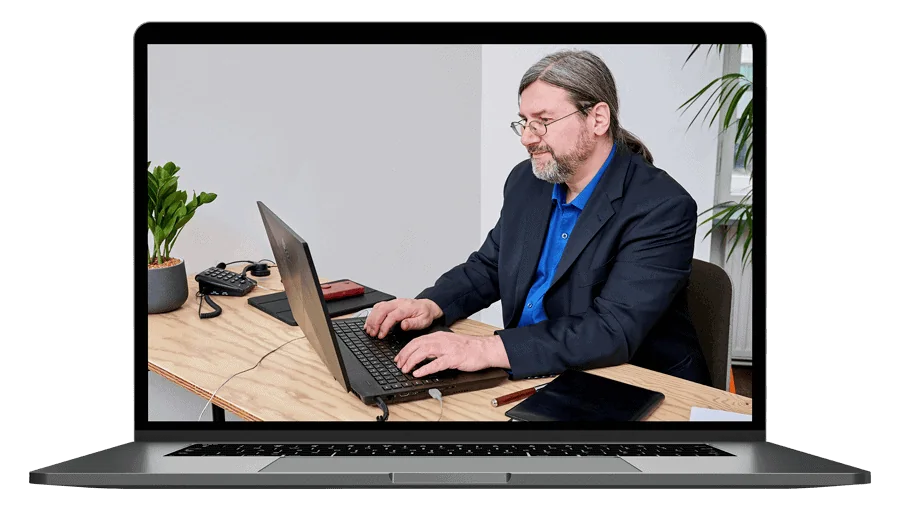 Laptop-Mockup mit Mann in Anzug und blauem Hemd an Schreibtisch arbeitend