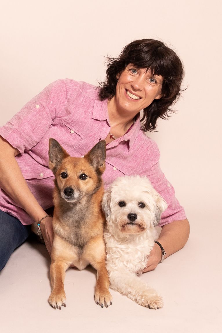 Kalyani Kathleen Reinhold in rosa Hemd mit zwei Hunden - Schäferhund und weißem Terrier