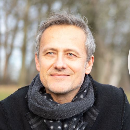 Porträt von Günter Kerschbaummayr mit weißem Haar in roter Jacke vor Grünfläche