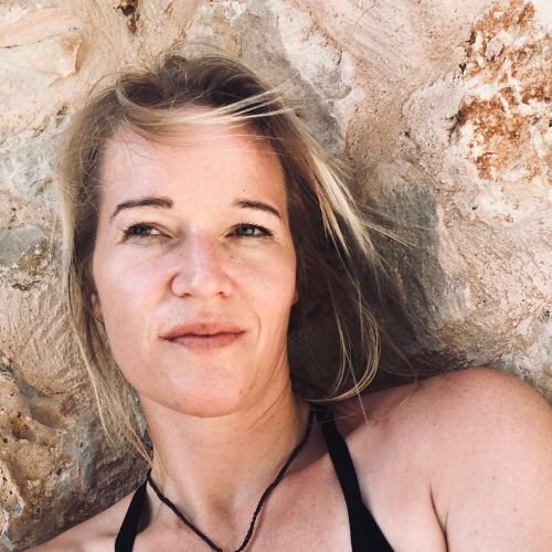 Porträt von Nicolette Muray mit braunen Haaren vor rustikaler Steinmauer