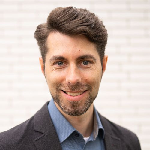 Porträt von Steffen Padberg, Mann mit braunem Haar und Bart in blauem Hemd und dunkelm Jacket