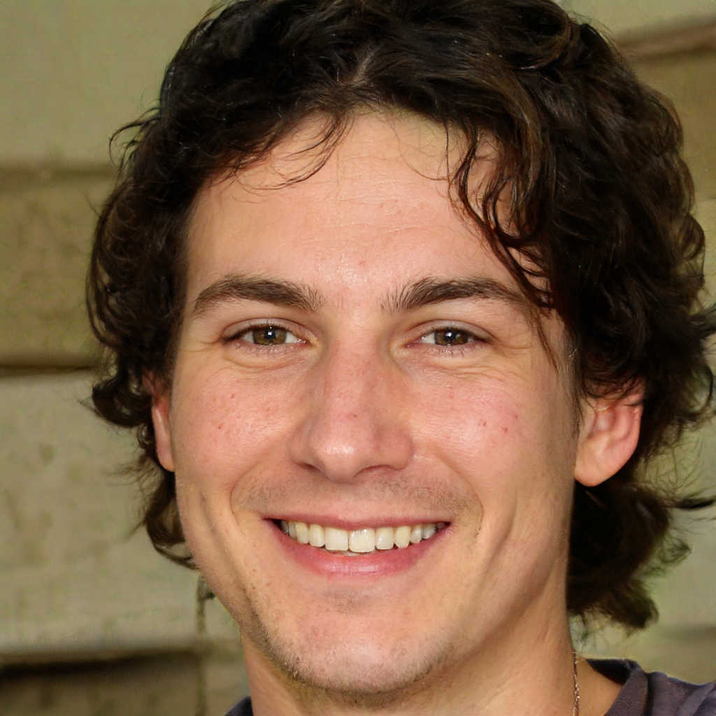 Trading-Code Praxiskurs – Videokurs für Trading-Einsteiger 8 Porträt Alexander Herder, Mann mit dunklen Locken in dunklem Hemd, lächelnd