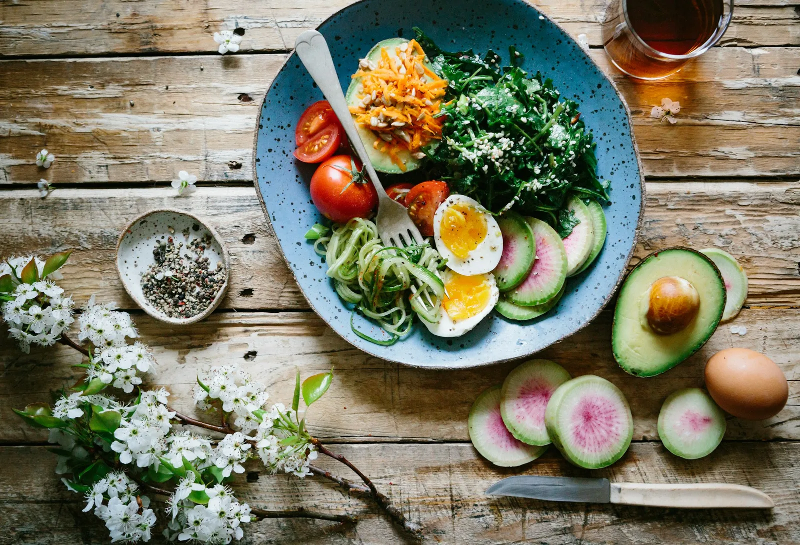 Gesundes Essen auf blauem Teller mit Avocado, Eiern und Gemüse
