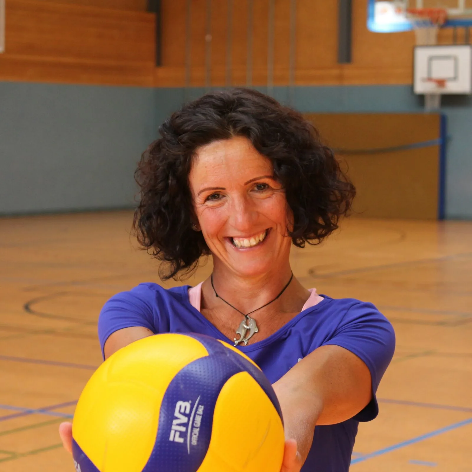 Diana Granchi Volleyballspielerin in blauem Trikot mit Ball in Sporthalle