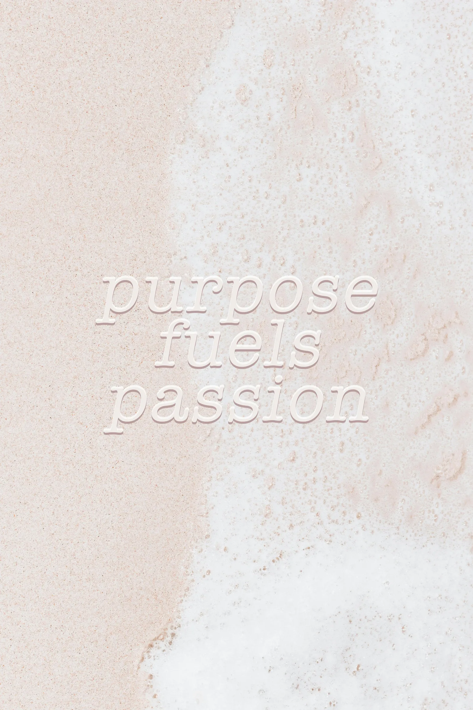 Sand-Textur mit weißem Prägungstext "purpose fuels passion"