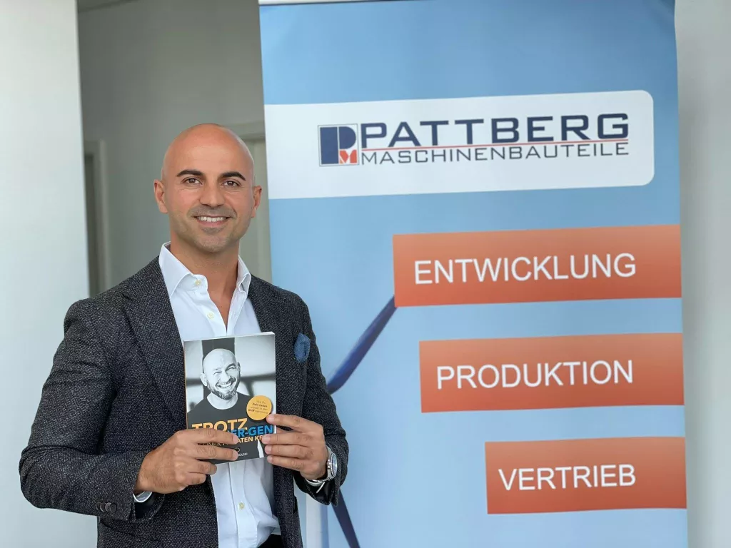 Mann im Business-Outfit hält das Workbook vor Unternehmens-Banner