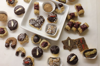 Overhead-Aufnahme von selbstgemachten Rohkost-Weihnachtskeksen und Pralinen auf weißem Tablett