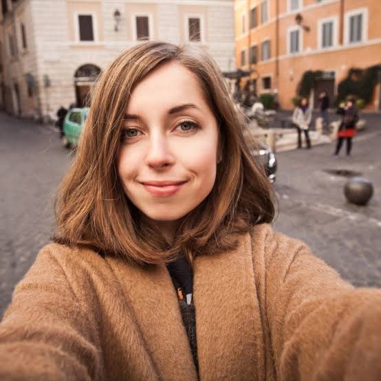 Mariam Haddad, Frau mit braunem Haar in Beige-Jacke vor römischer Architektur