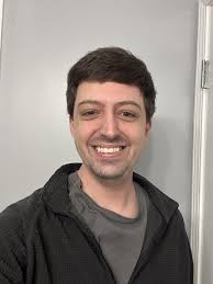 Alejandro Rojas, lächelnder Mann mit dunklem Haar in grauem Pullover