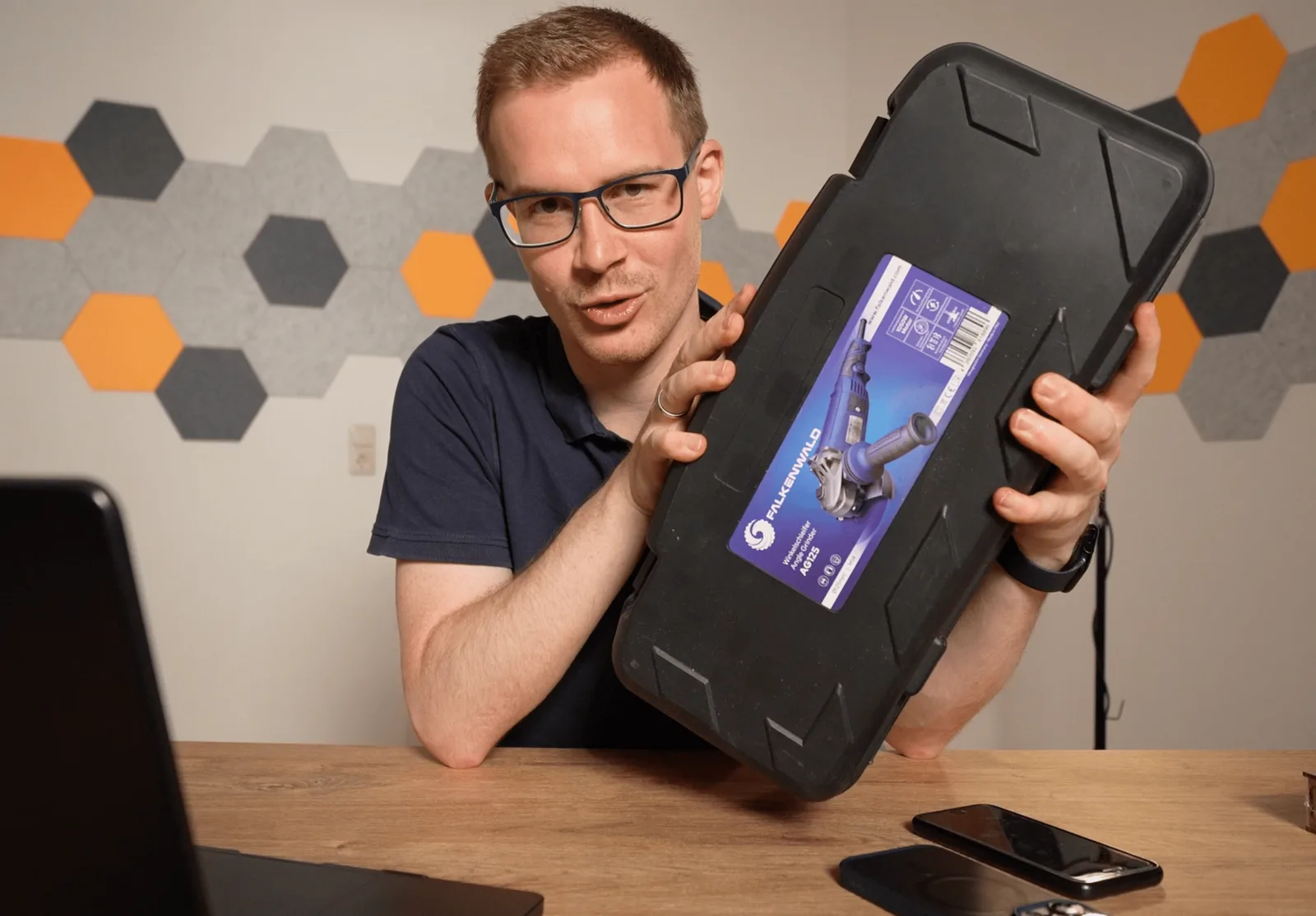 UGC Videokurs – Kurs zu User Generated Content von Simon Knobloch 6 Mann mit Brille hält schwarzen Werkzeugkoffer mit Aufkleber präsentativ