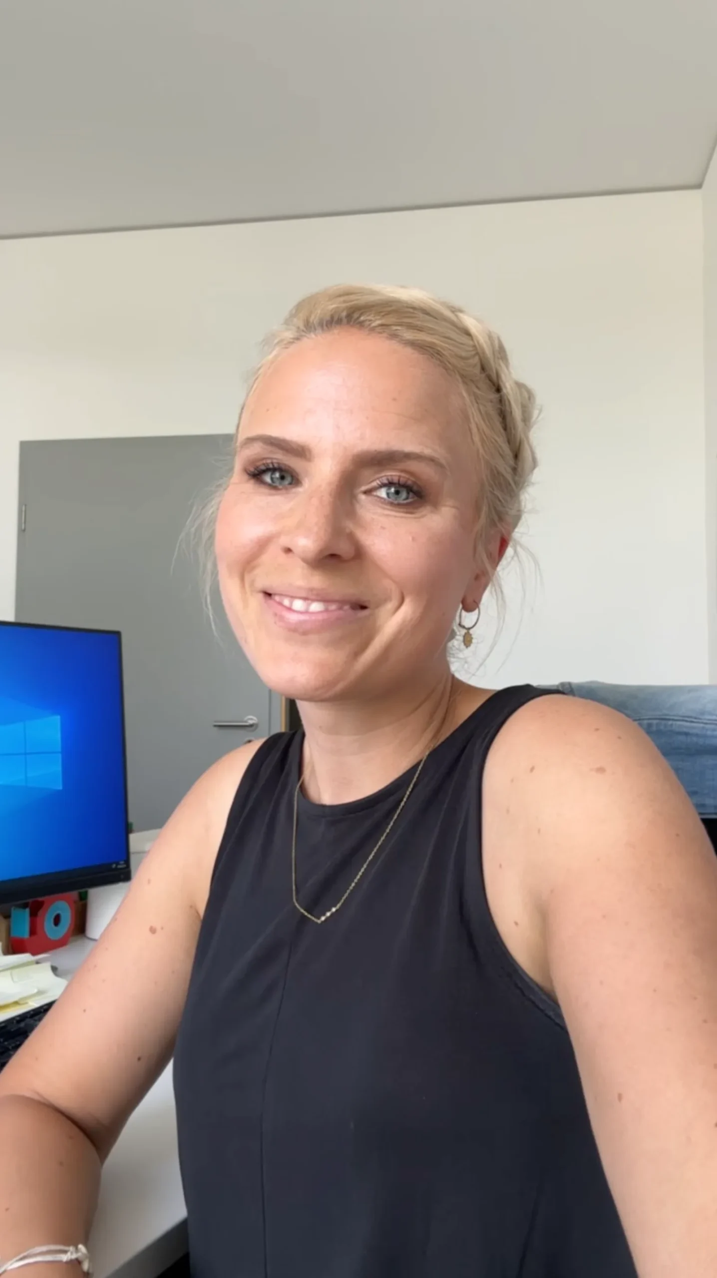 UGC Videokurs – Kurs zu User Generated Content von Simon Knobloch 8 Blonde Frau am Arbeitsplatz mit Monitor, trägt schwarzes Tanktop