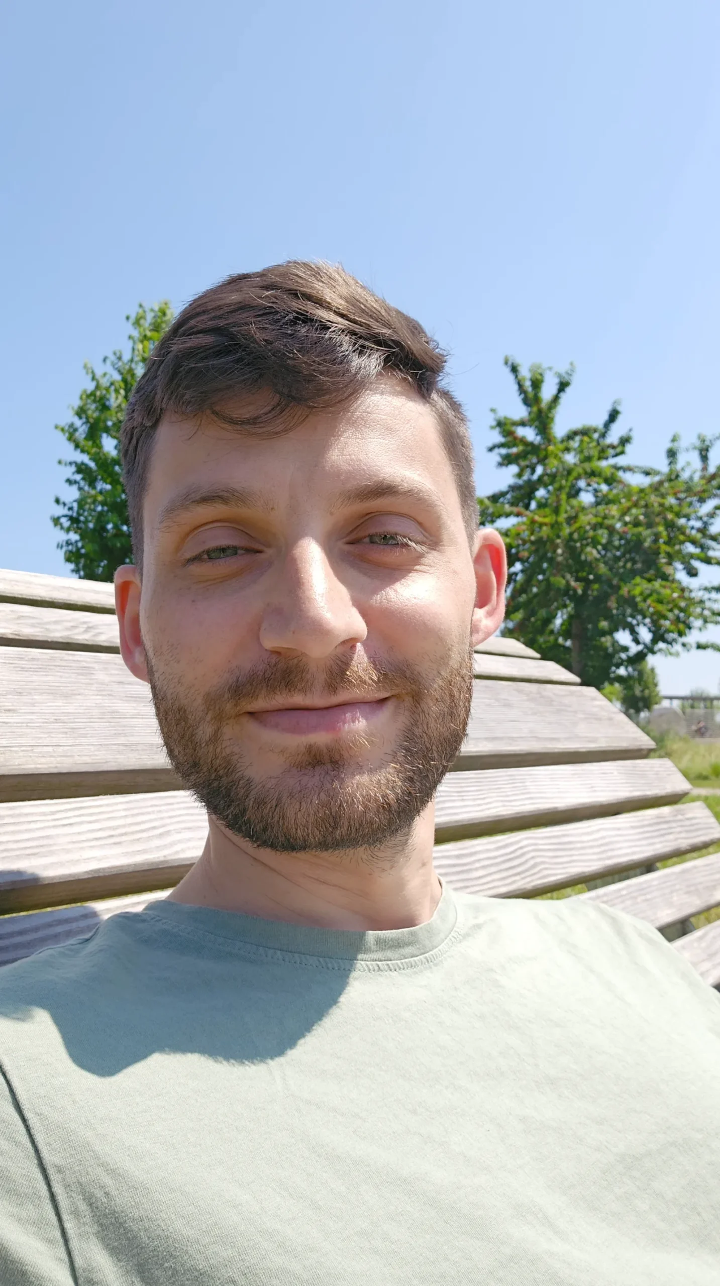 UGC Videokurs – Kurs zu User Generated Content von Simon Knobloch 9 Mann mit Bart im Freien auf Holztreppe vor bewölktem Himmel