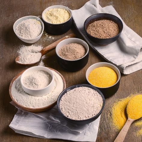 Verschiedene vegane Backzutaten in Schüsseln: Mehl, Stärke, Speiseöl und Gewürze