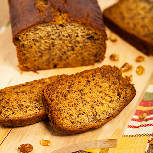 Aufgeschnittenes Easy Banana Bread auf Holzbrett mit Krümeln