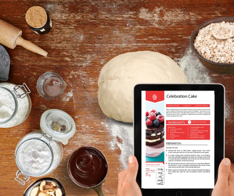 Backzutaten auf Holztisch mit Tablet zeigt Celebration Cake Rezept