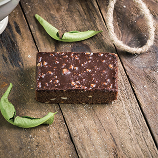 Chocolate Peanut Butter Fudge Riegel auf Holz mit grünen Schoten