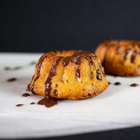 Veganer Guglhupf mit Schokoladenguss auf weißem Tablett