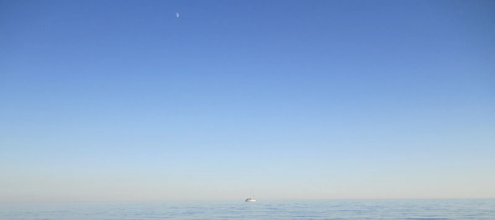 Minimalistisches Hero-Banner mit Segelboot auf ruhigem Meer unter blauem Himmel