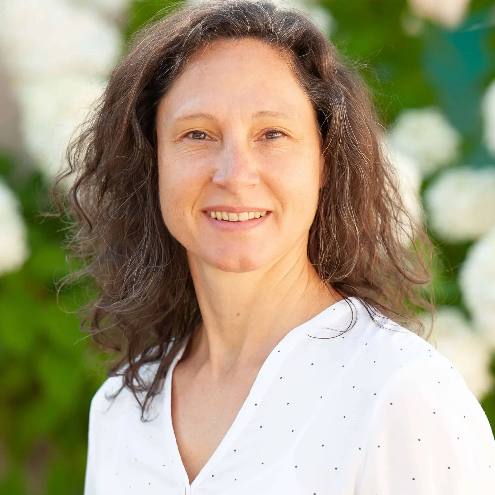 Porträt von Valeska Otto mit braunen Haaren und weißem gepunkteten Top