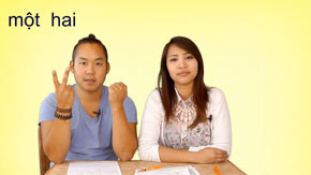 Videostandbild mit zwei Personen zeigt vietnamesische Zahlen één hai mit Handgesten