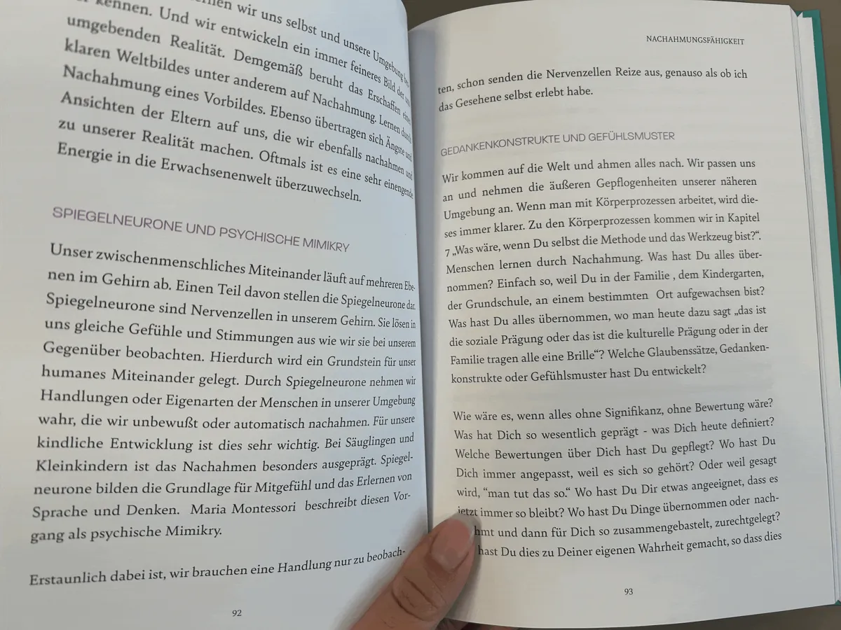 Aufgeschlagenes Buch mit ausführlichem Text zu Spiegelneuronen und Nachahmmungsfähigkeit auf Seite 92-93