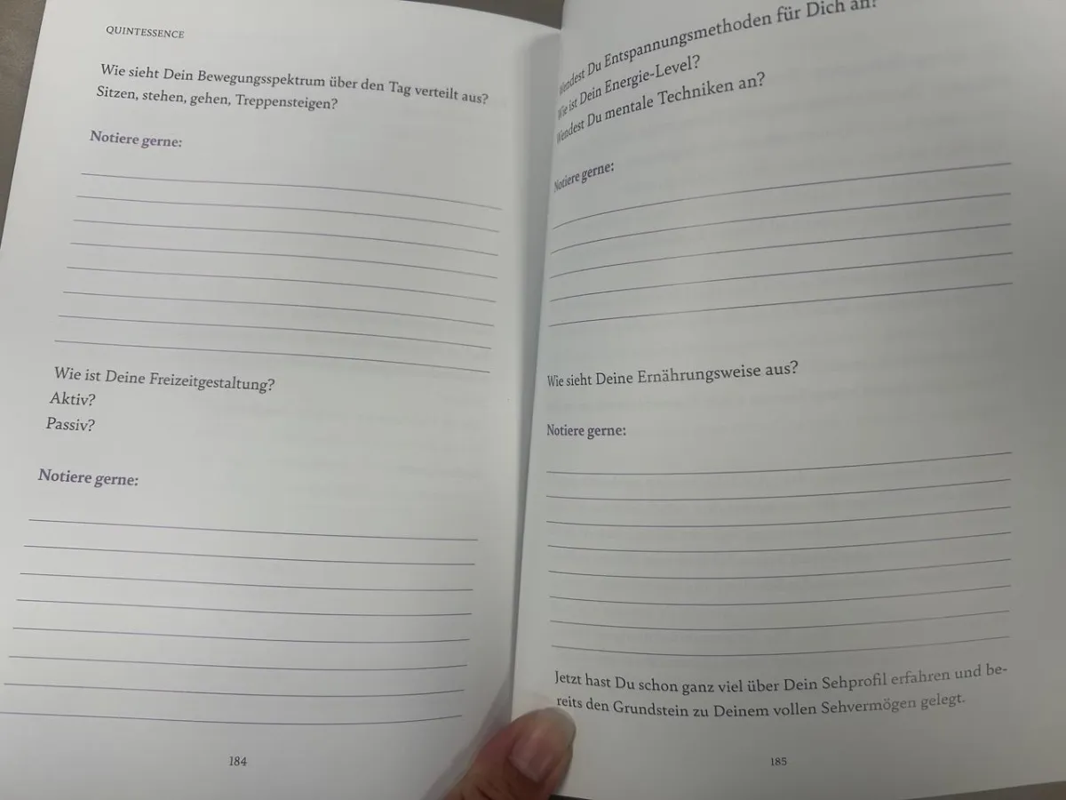 Aufgeschlagenes Buch Seiten 184-185 mit Übungsfragen und Schreiblinien, vollständige Ansicht