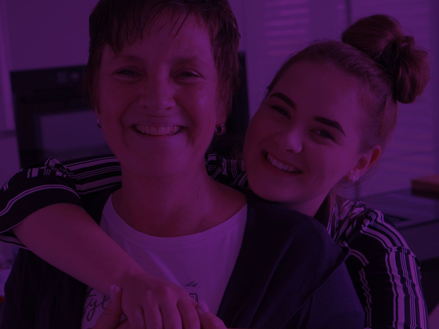 Zwei Frauen lachen gemeinsam vor lila Hintergrund, Authentizitätsfoto