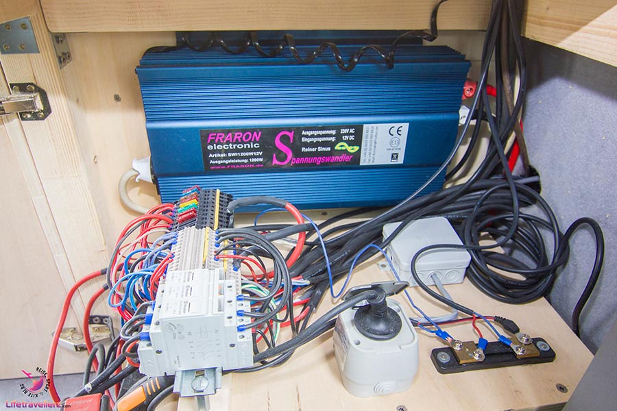 VW T5 Bus Ausbau Elektrik mit blauem Spannungswandler und Verkabelung