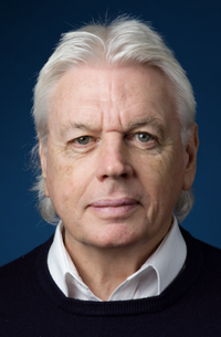 Porträt David Icke, älterer Mann mit weißem Haar vor blauem Hintergrund