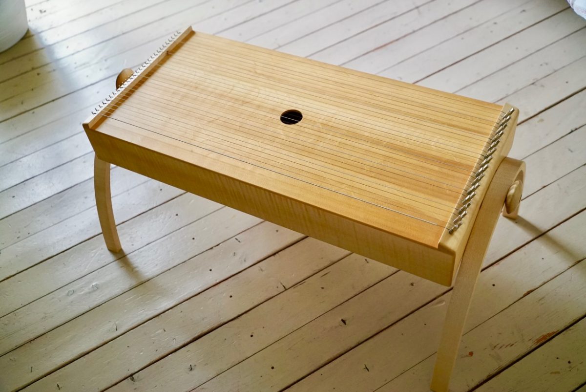 Körpertambura Musikinstrument aus Holz auf hellem Holzboden fotografiert