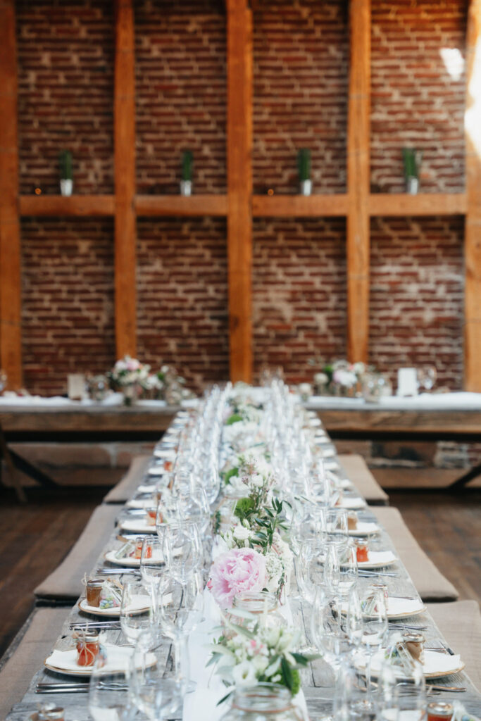 Hochzeitstafel mit Blumendekoration und Besteck in modernem Saal
